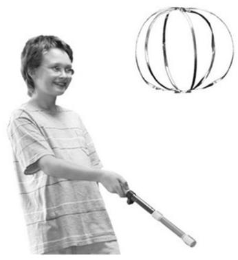 Persona utilizando el Fun-Fly-Stick para hacer levitar un objeto metálico circular.